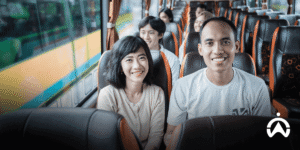 Man and woman smile while on a sightseeing trip on a bus