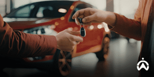 Key handover between owner and renter to minimize the risk of car rental business with a red car background.