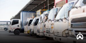 A row of white delivery trucks in the loading and unloading area of ​​a distribution facility