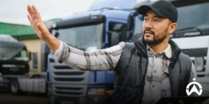 A man gives directions in front of a fleet of trucks to reduce downtime with the transportation company's fleet management system.