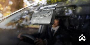 The dash cam integrated GPS vehicle tracker is mounted on the car windshield for driver safety.
