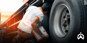 Officers check truck tires using a clipboard as part of the Fleet Management System to ensure driving safety.