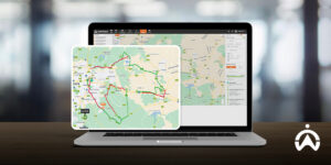 Laptop di atas meja menampilkan peta rute pengiriman, memuat informasi penting kendaraan dan navigasi dalam satu aplikasi.