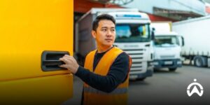 Logistics manager standing in front of a row of trucks