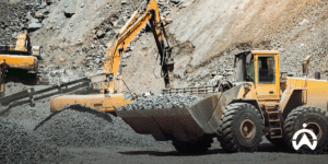 Yellow excavators and loaders move rocks in the quarry to reduce idle habits in fleet operations.