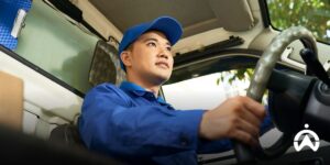 Seseorang mengelola biaya operasional kendaraan menggunakan kalkulator dan laptop melalui dasbor Fleet Web Cartrack.