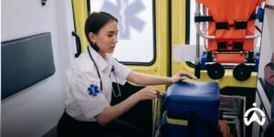 Paramedics are preparing medical equipment inside the ambulance with vehicle tracking system for efficient emergency services.