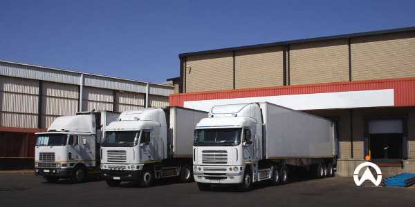 Truk logistik rantai dingin putih parkir di gudang untuk distribusi produk sensitif suhu