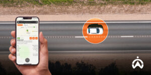 Tampilan smartphone yang menunjukkan cara sistem pelacakan kendaraan bekerja untuk memantau posisi mobil putih di jalan.