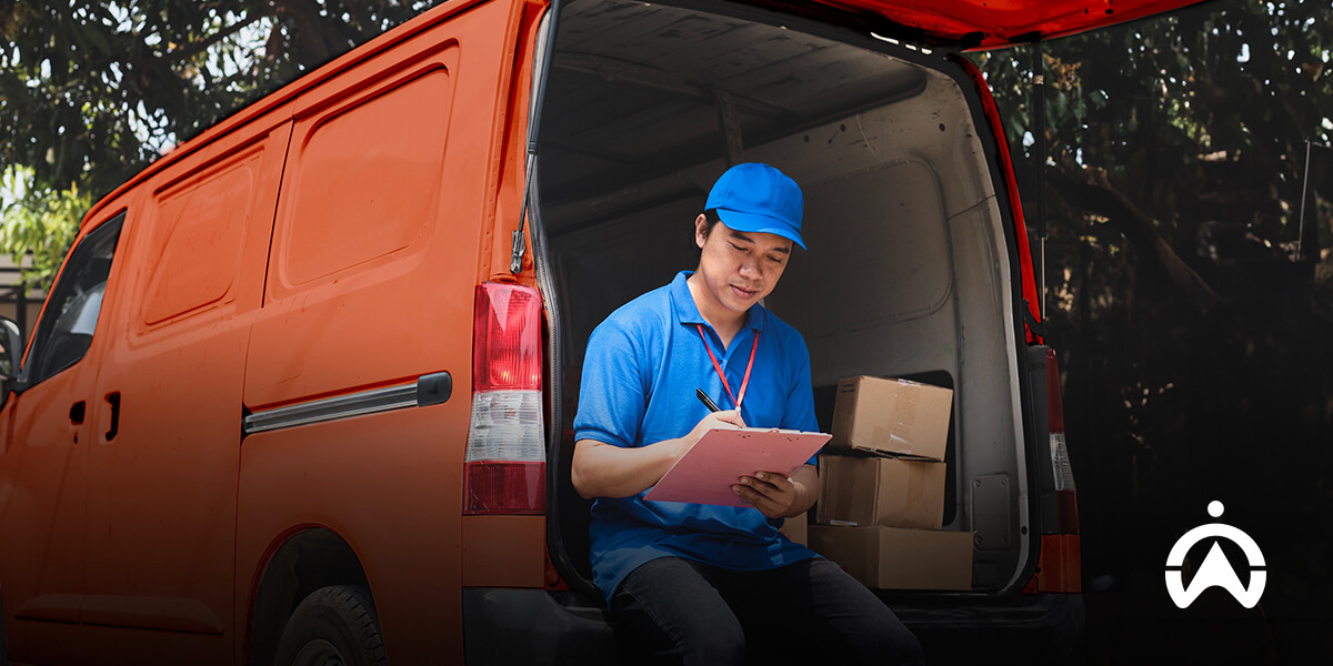 Kurir sedang mencatat jadwal logistik di dalam van untuk meningkatkan pengiriman tepat waktu dan performa OTIF
