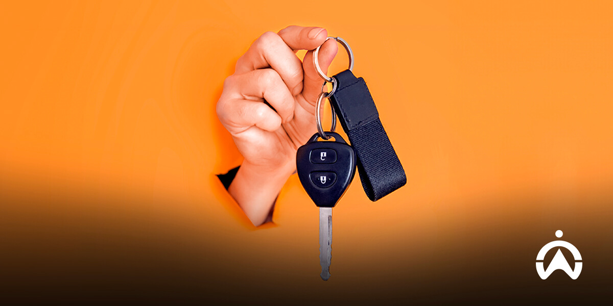 Tangan memegang kunci mobil sebagai persiapan waktu terbaik untuk menjual mobil.