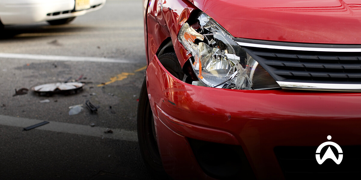 Mobil merah dengan bagian depan penyok akibat kecelakaan, menunjukkan pentingnya dashcam kendaraan sebagai bukti.