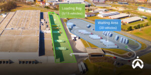 Foto udara hub logistik menggunakan sistem pemantauan kendaraan untuk melacak truk di loading bay dan area tunggu.