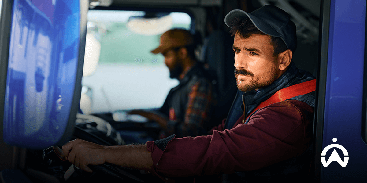 Dua sopir di dalam kabin truk yang mengutamakan keselamatan dan kesejahteraan sopir selama perjalanan.