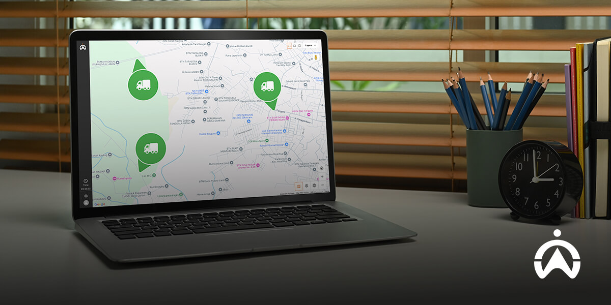 Laptop di meja kerja menampilkan peta rute pengiriman barang sebagai contoh penggunaan Internet of Things (IoT) di sektor logistik.