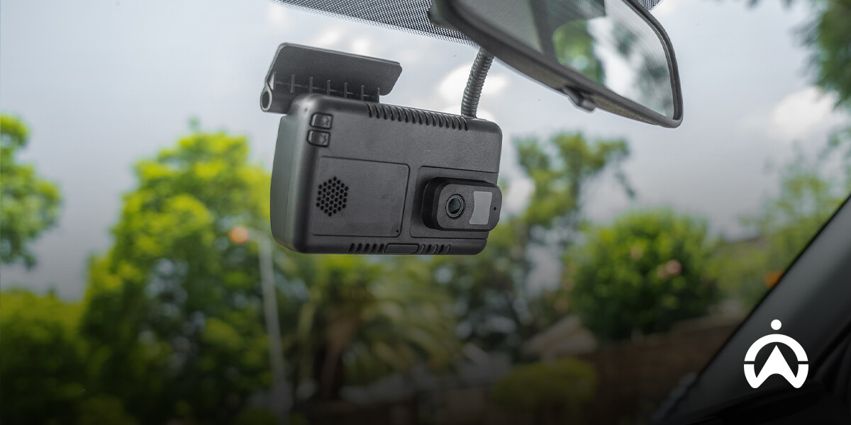 Kamera dashcam terpasang di kaca depan mobil untuk memantau kondisi idle pada kendaraan operasional perusahaan.