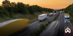 Trucks pass on the toll road at sunset to save fuel while driving.